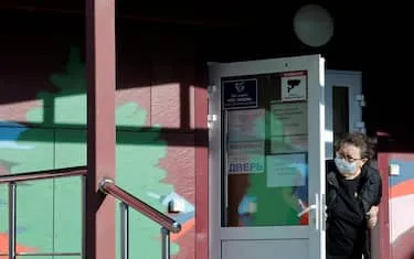 A security person wearing a face mask looks out from the door of an infectious diseases hospital in the town of Shelekhov, where an employee of the Irkutsk Antiplague Research Institute had died, in the Irkutsk region on October 7, 2026. (P